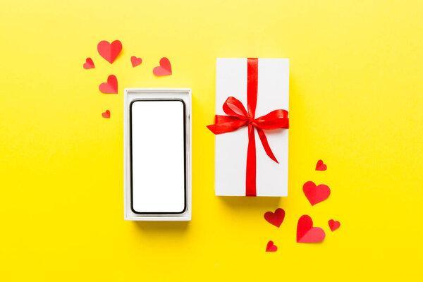 Opened gift box with ribbon and phone on color background, top view. Blank open box packaging mockup , Template for your design - branding mockup.