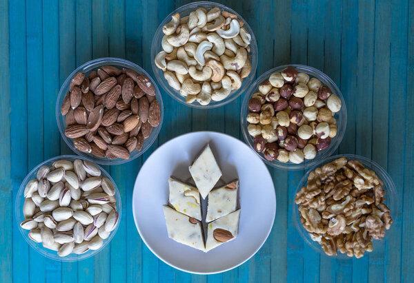 Oriental dessert halva with pistachio, almond, cashew nuts, peanut, walnut  on a  plate. Image. Healthy food. Nuts mix assortment. closeup of sweets from Iran popular in many other regions of the world, at the Machane Yehuda Market, Turkish Delight. 