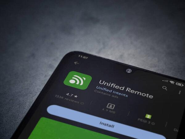 Lod, Israel - July 16,2023: Unified Remote app play store page on smartphone on a dark marble stone background. Top view flat lay with copy space.