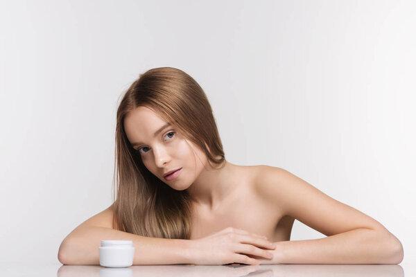 Beautiful spa girl with jar of cream isolated on white background