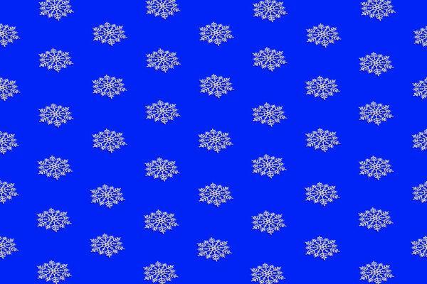 Winter pattern made of white snowflakes on bright blue background. Christmas and new year celebration concept. Holiday theme
