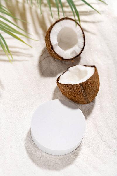Coconut beauty skincare scene for cosmetic product presentation. Mockup round scene on a sand, view above. Vertical photography.