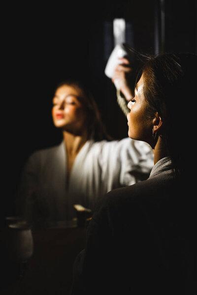 性感女人一次又一次地吹干她的头发。个人卫生概念