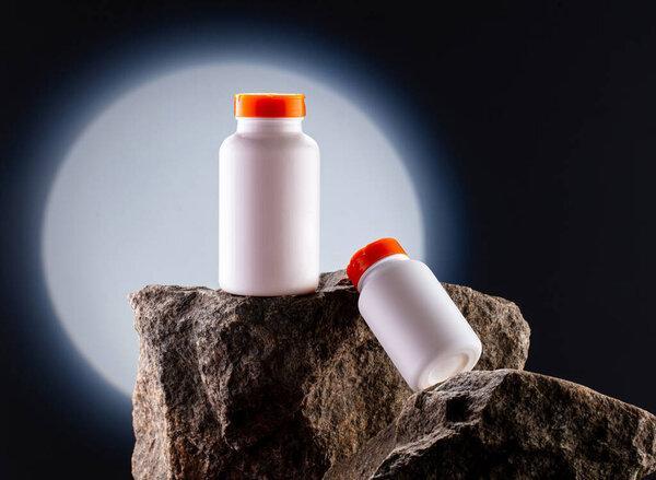 White jar mockup for vitamins on natural stone on dark background