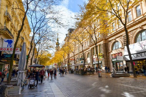Vienna, Austria October 7 2017: Busy pedestrian Krntner Strae shopping street with autumn trees and historic buildings.