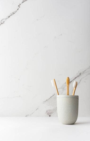 Wooden toothbrushes with natural bristles in a ceramic glass, natural oral hygiene products