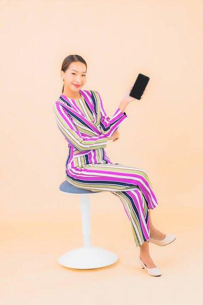 亚洲年轻貌美的女性在色彩隔离的背景下使用智能手机