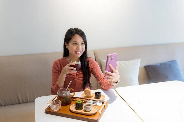 女人在咖啡店里用智能手机自慰