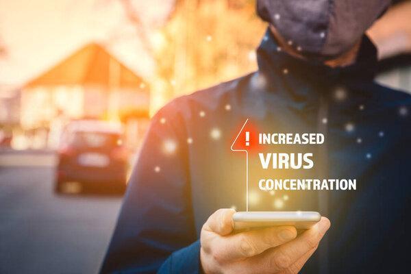 Increased virus concentration alert on smartphone concept. Man with mask and smartphone with notification about virus in epidemic times.