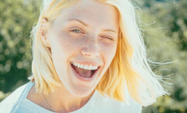 Funny crazy girl give a wink. Beautiful Young Woman with Clean Fresh Skin and blonde hair. Perfect clean skin. Beauty portrait of female face with natural skin