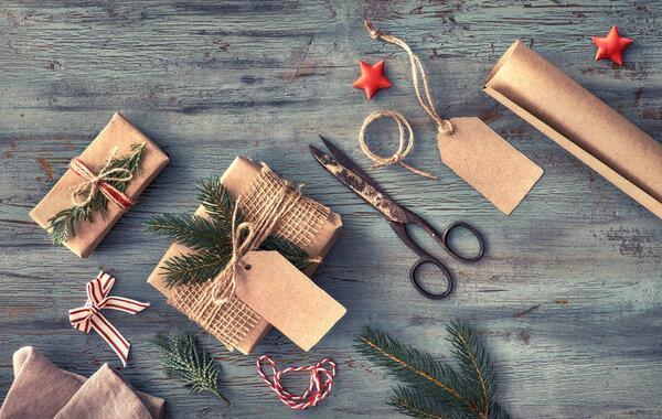 Hand crafted gifts on dark rustic wooden table with Christmas de