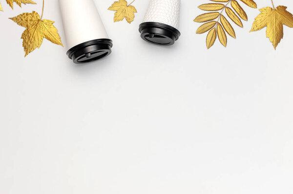 Coffee or tea paper cups, golden autumn leaves on light gray background top view flat lay. Take away coffee cup, mockup. Coffee love, layout for design. Fall concept. Autumn background. Copy space