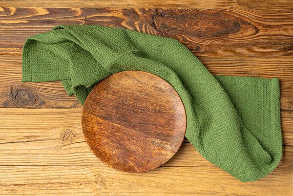 Empty Plate on Wooden Table Top View with Copy Space for Text, Rustical Kitchen Mock Up with Green Tablecloth, Eco Plate on Cloth Napkin Fabric