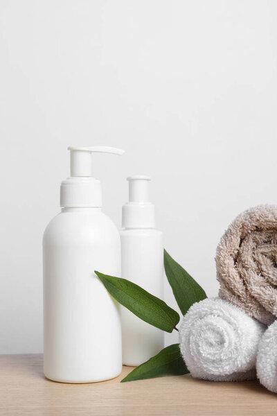木桌上的化妆品、叶子和毛巾盒