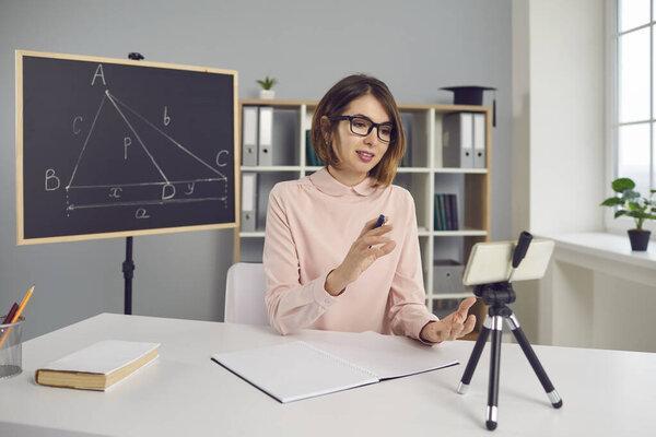 Young remote college or school teacher having online geometry class via video call