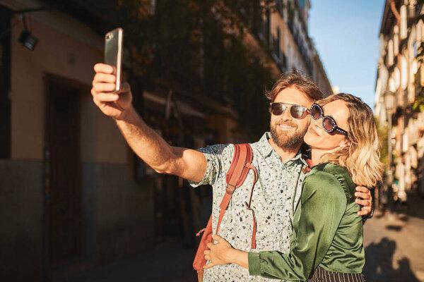 Couple walking on street taking a selfie