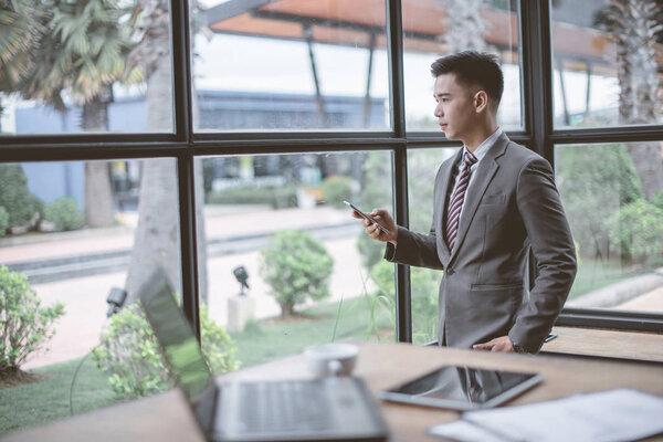 Portrait of businessman talking on mobile phone in office