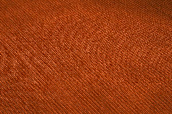 Textured corduroy furniture fabric in orange colors close-up