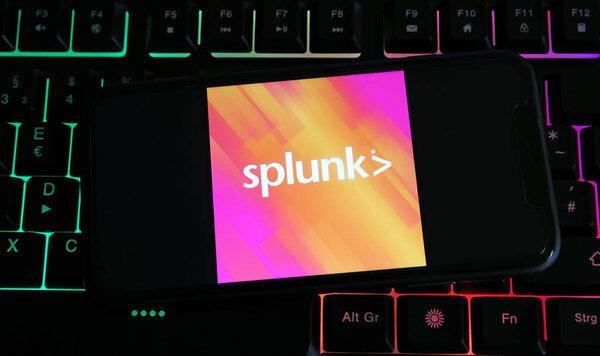德国维尔森- 7月9日。2023:用Splunk公司的标志字母在电脑键盘上关闭移动电话