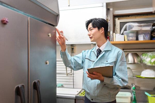 一个检查餐馆冰箱的男人