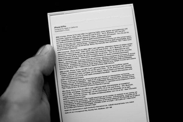 英国伦敦- 2022年9月28日：一张黑白照片捕捉到一个男人拿着苹果电脑最新推出的iPhone 14 Pro智能手机，将永恒的美学与尖端技术融为一体