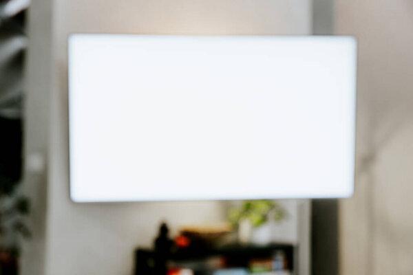 TV at wall in living room. Watching smart television indoors. White empty mockup screen, copy space. Movie stream service. Video on demand subscription platform. Manage appliances of smart home