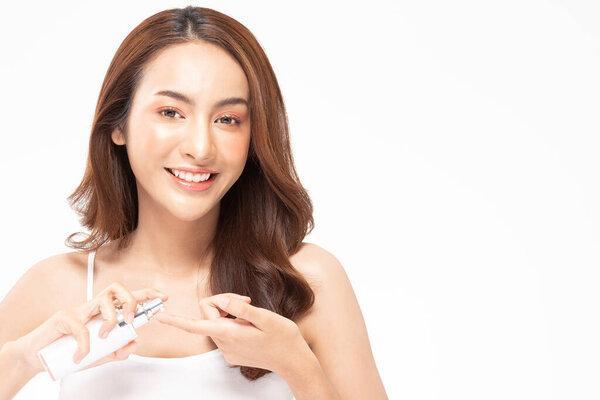 Beauty asian woman  brown hair looking smile in camera happiness and hold bottle cosmetic cream lotion  and cheerful with make up brush,Beauty Concept on white background.