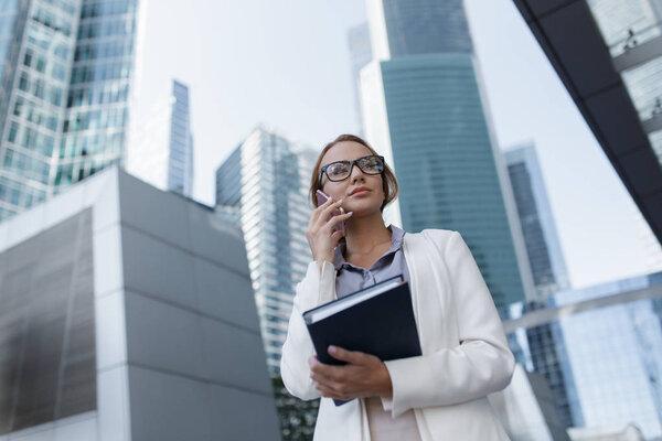 Attractive young girl talk on phone during walking to office.