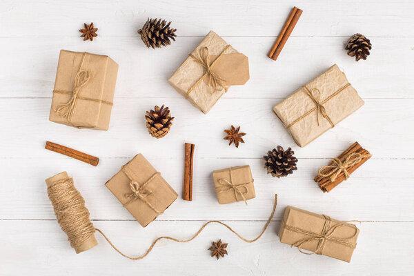 Kraft paper gifts and spices on a white table. The original decor for Christmas. Beautiful layout, top view, flat lay.