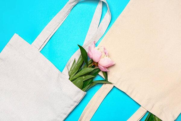 Eco bags with flower on color background