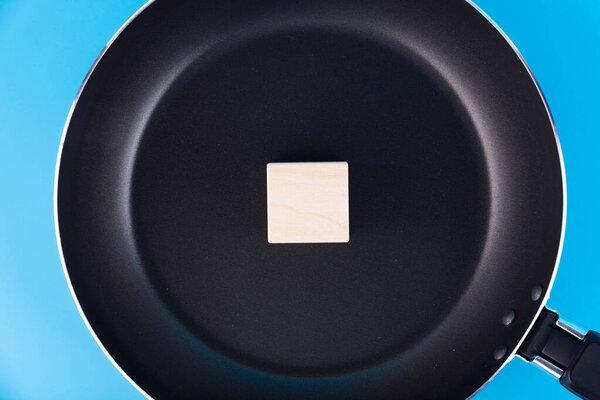 The concept of writing text, symbol, sign on a wooden block, cube of one letters, lying in a frying pan. Idea, frying. hot wi fi