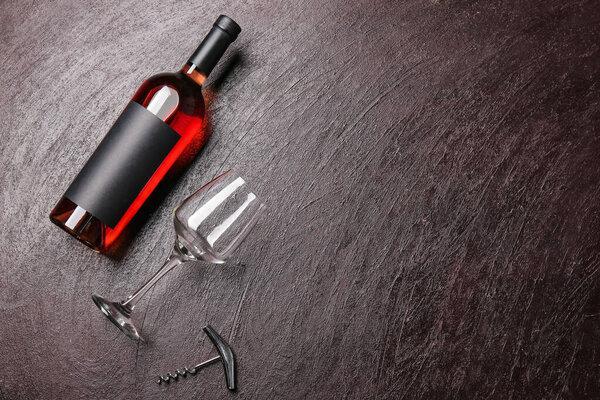 Glass and bottle of wine on dark background