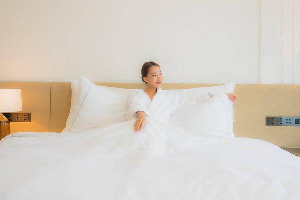 Portrait beautiful young asian woman relax smile leisure on bed in bedroom interior