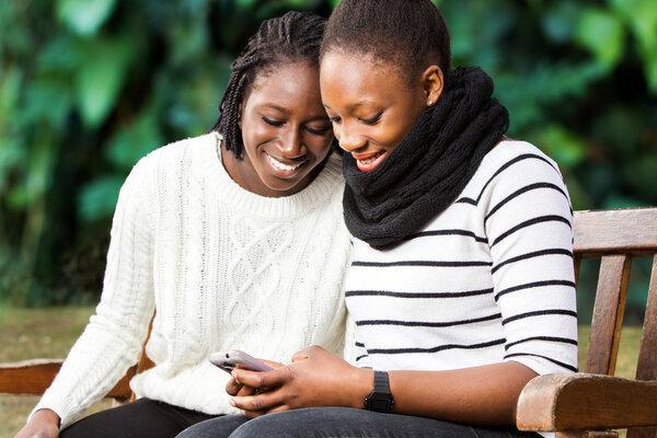Teenage girlfriends socializing on phone.