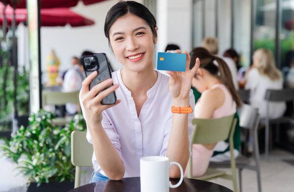 坐在咖啡店前的美丽的亚洲女人的画像