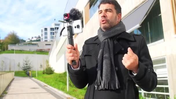 成年男性 vlogger 穿着优雅的冬装在城市录制在线视频