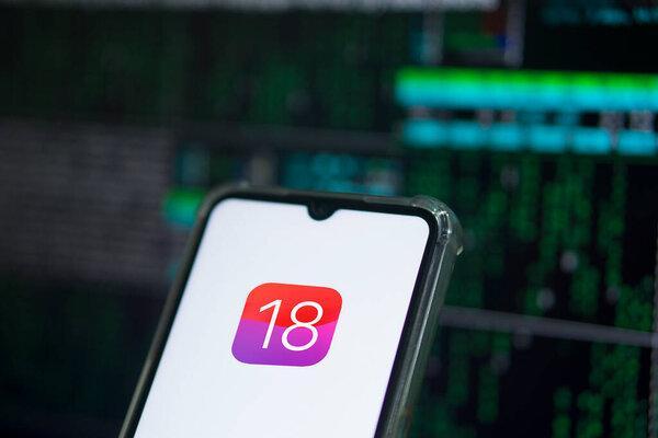 Dhaka, Bangladesh- 05 Apr 2024: Apple IOS 18 icon on smartphone and Apple logo on the background.