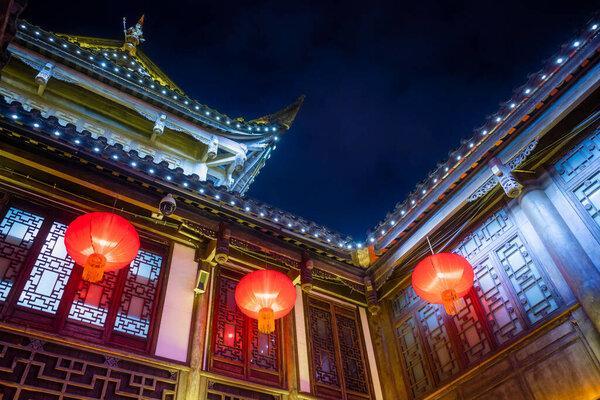 在中国四川省成都市锦里古街，夜晚传统中式建筑上挂着的红色中国灯笼。