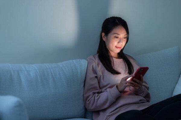 Woman use mobile phone and sit on sofa at home