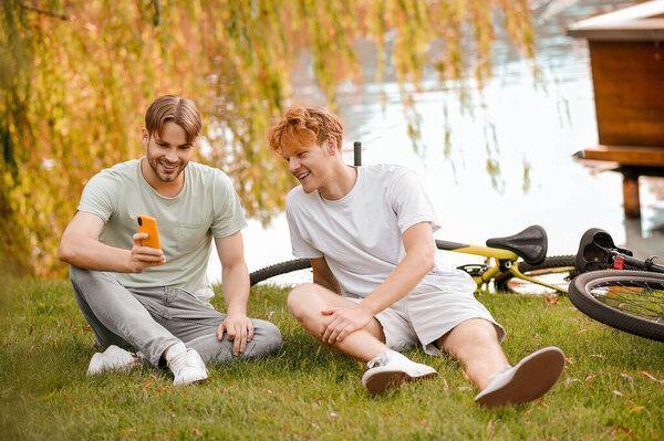 Two smiling pals looking at the cellphone screen