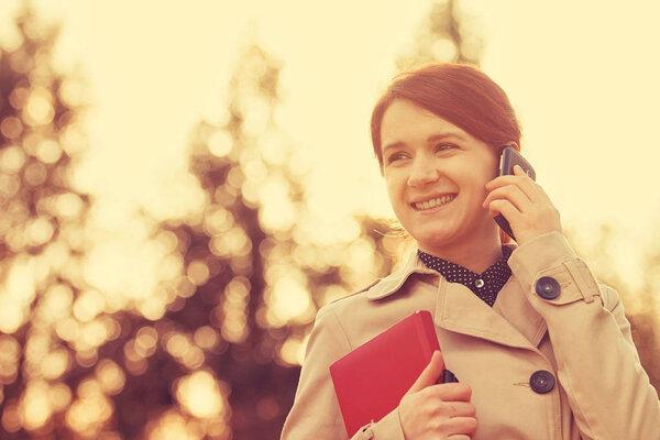 Young smiling businesswoman,student professional outdoors talking on cell smart phone
