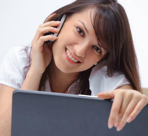 smiling young woman sitting behind a Desk and showing thumb up.