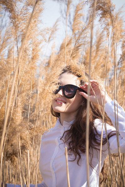 Outdoor fashion photo of young beautiful lady in glasses,model photos in the reeds