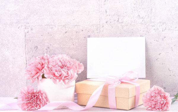 May mothers day handmade giftbox wishes photography - Beautiful blooming carnations with pink ribbon box isolated on fair-faced gray background desk, close up, copy space, mock up