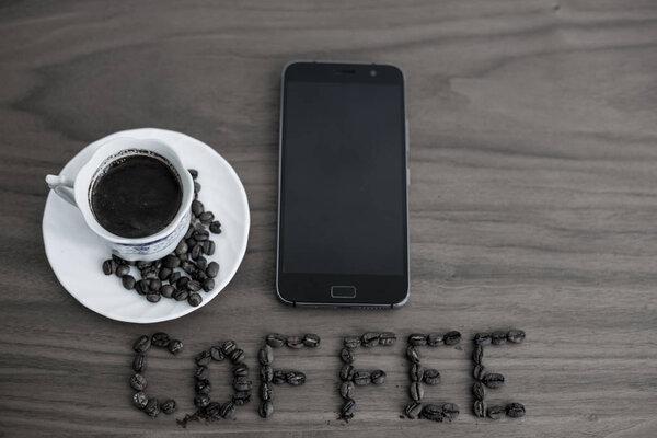 Roasted coffee beans, scattered on the table and written Coffee,