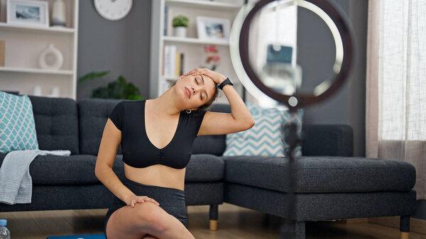 年轻美丽的惊慌失措的女人在家里记录视频教学训练