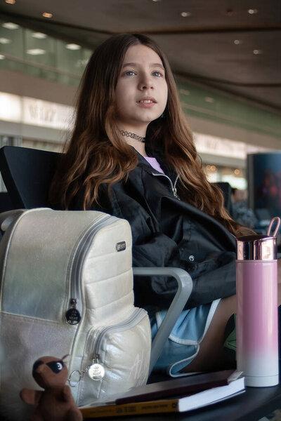 带着行李、书籍和宠物的女孩在国际机场停留