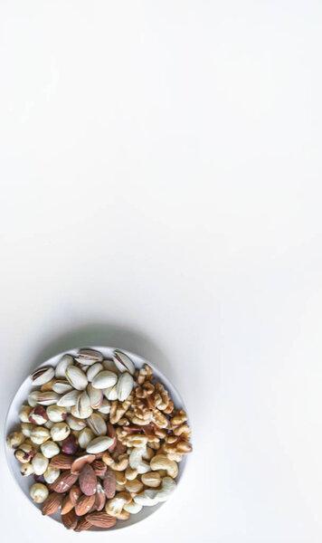 Healthy food. Nuts mix assortment on white grey table top view. Collection of different legumes for background image close up nuts, pistachios, almond, cashew nuts, peanut, walnut. image