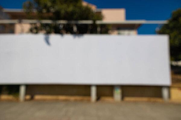 Defocused white blank billboard in the city. Marketing or advertising background photo.
