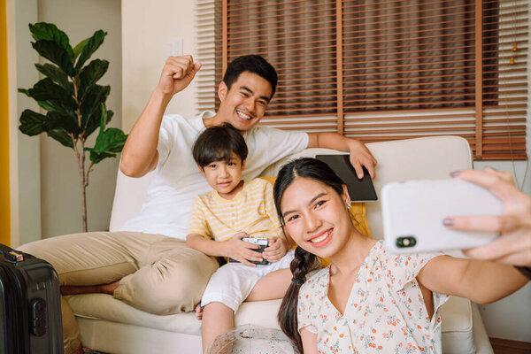 Asian thai family taking selfie with smartphone together before traveling.